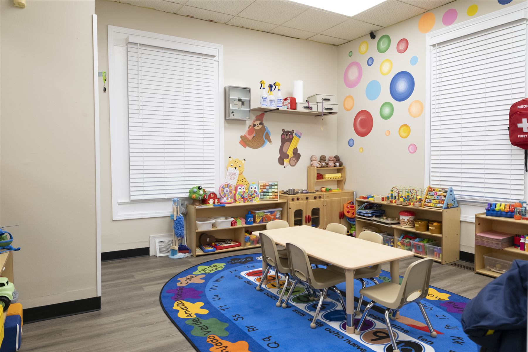Toddler classroom with play kitchen and learning rug